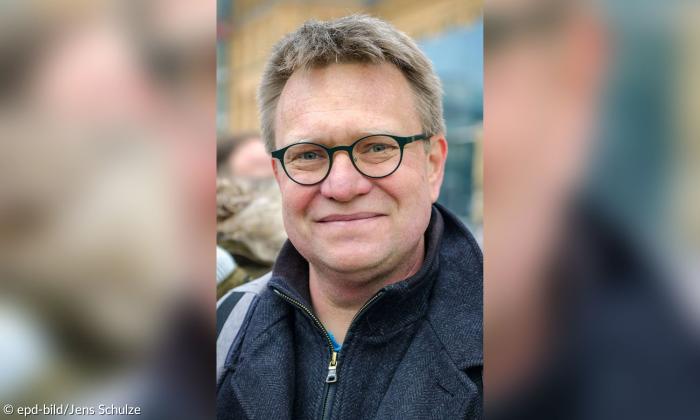 Ein Mann mit Brille, er lächelt
