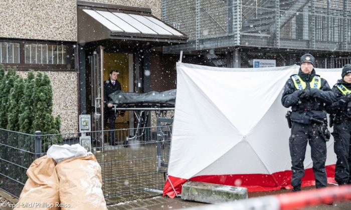 Ein Gebäude, vor dem Polizeibeamte stehen