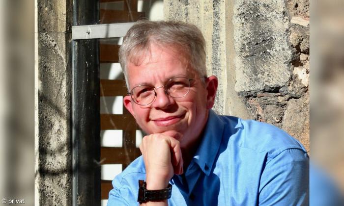 Ein Mann mit Brille im blauen Hemd