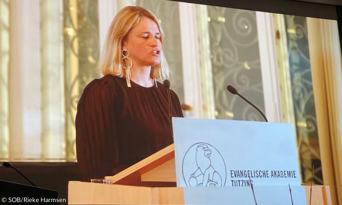 Eine Frau an einem Rednerpult, auf dem "Evangelische Akademie Tutzing" steht