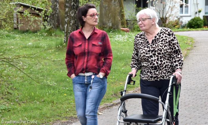 Zwei Frauen, eine mit Rollator