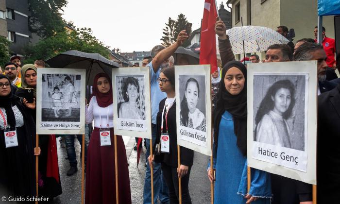 Menschen mit Plakaten der Anschlagsopfer