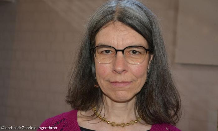 Porträtaufnahme einer Frau Anfang Fünfzig. Sie trägt eine Brille, hat schulterlanges Haar und blickt mit einem leichten Lächeln in die Kamera.