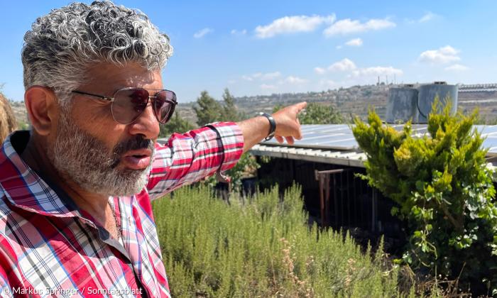 Von Siedlungen umgeben, die eigene Solaranlage vom Abriss bedroht: Daoud Nassar (52) deutet auf den Kibbuz Rosh Tzurim ("Felsenspitze" oder "Felsenkopf") im Südwesten des Hügels seiner Familie.