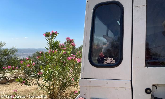 "Gerechtigkeit ist Liebe in Aktion" steht auf einem Aufkleber auf Daoud Nassars Land Rover.