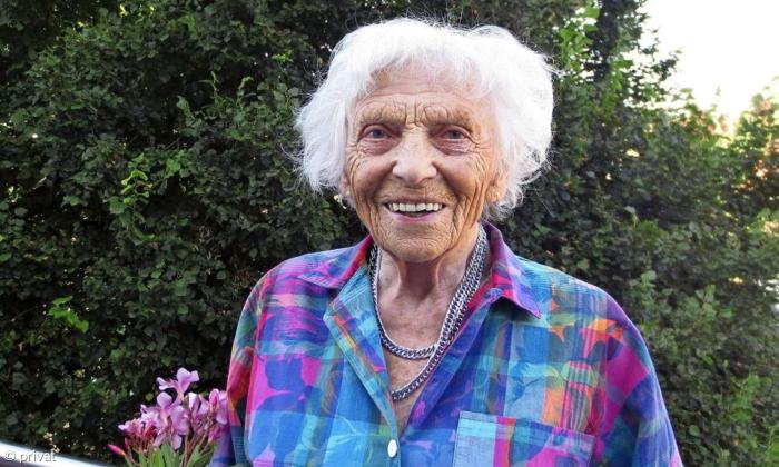Eine Frau mit weißen Haaren, sie lächelt