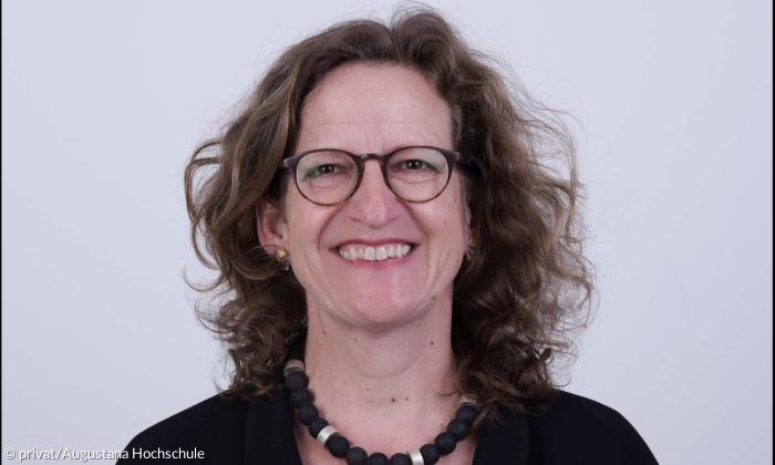Eine Frau mit Brille, sie lacht