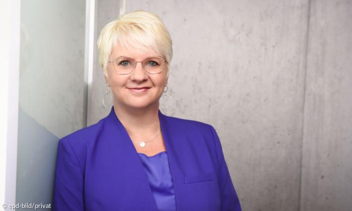 Eine Frau im fliederfarbenen Blazer
