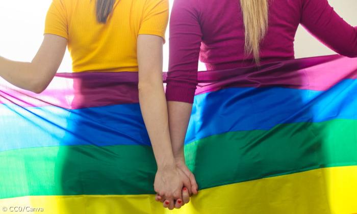Eine Regenbogenfahne und zwei Frauen