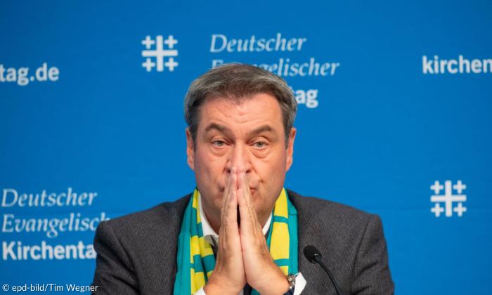 Ein Mann mit den Händen vor dem Mund