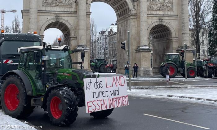 Ein Traktor mit einem Plakat, auf dem "Ist das Land ruiniert wird Essen importiert" steht