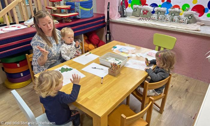 Eine Frau mit drei Kindern am Tisch