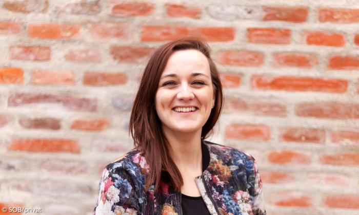 Eine Frau mit rotbraunen Haaren, sie lacht