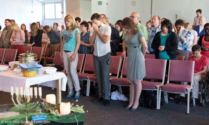 Menschen stehen in einem Gottesdienst