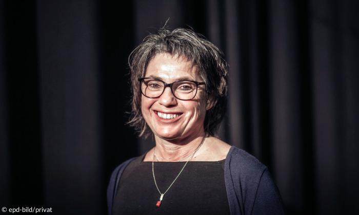 Eine Frau mit Brille, sie lacht