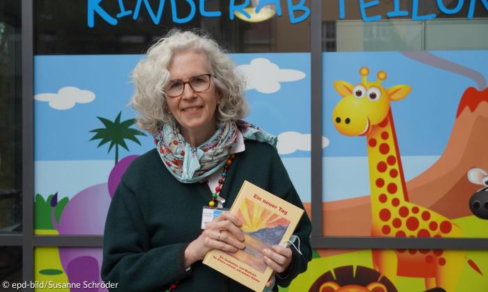 Eine frau hält ein Buch in die Kamera