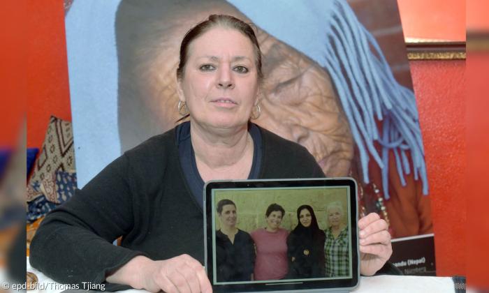 Eine Frau mit einem Tablet, auf dem vier Frauen zu sehen sind