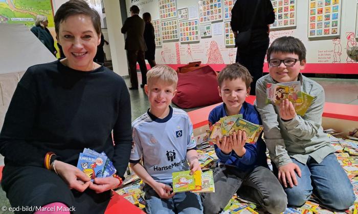 Eine Frau und drei Kinder mit Pixi-Büchern
