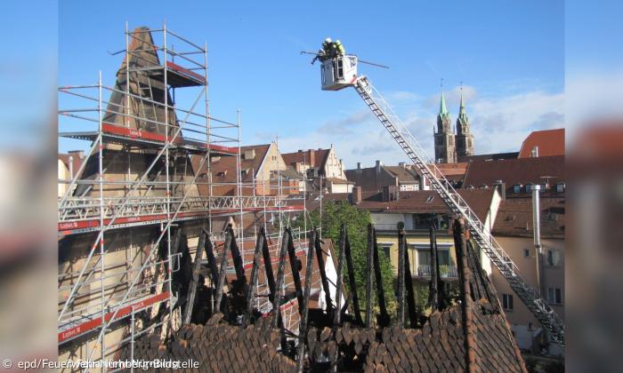 Eine abgebrannte Kirche mit Gerüst, davor ein Kran