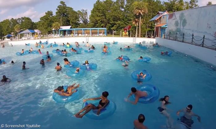 Ein Schwimmbecken voll mit Kindern, viele haben einen blauen Schwimmreifen