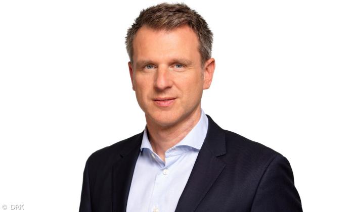 Ein Mann im Anzug schaut in die Kamera