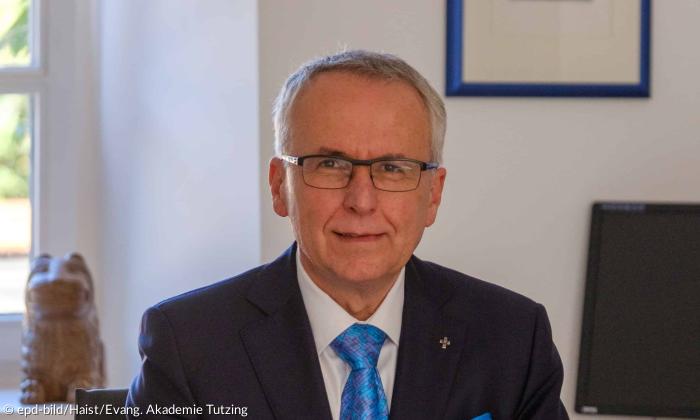 Ein Mann mit Brille und kurzen, grauen Haaren blickt in die Kamera
