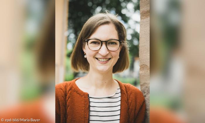 Eine Frau mit Brille, sie lächelt
