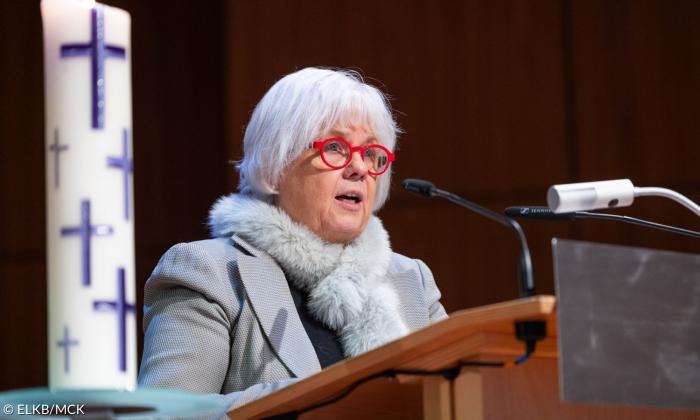 Eine Frau mit roter Brille am Rednerpult