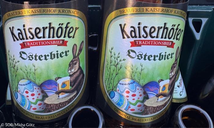 Zwei Etikette von Bierflaschen, darauf ein Hase mit Eiern und der Aufschrift "Osterbier"