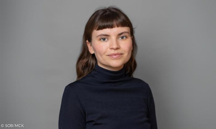 Eine Frau in einem schwarzen Rollkragenpullover