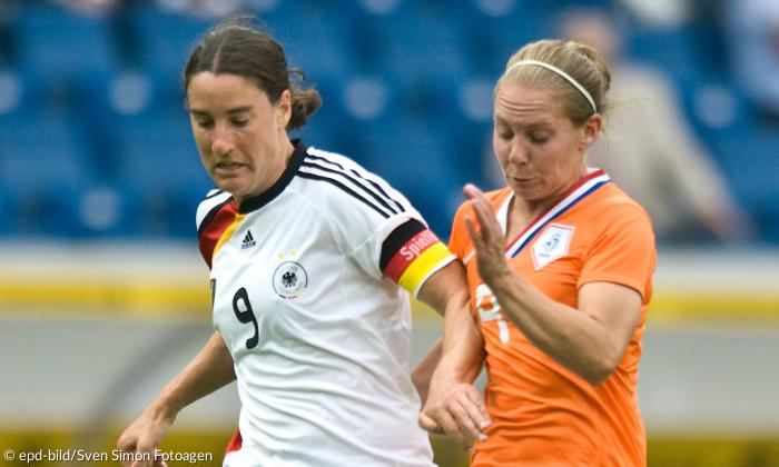 Zwei Frauen in Fußball-Trikots im Zweikampf