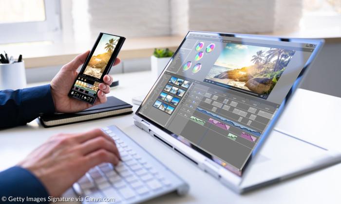 Ein Laptop und ein Handy, auf dem Schnittprogramme geöffnet sind
