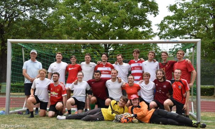 Menschen in einem Fußballtor, in Trikots