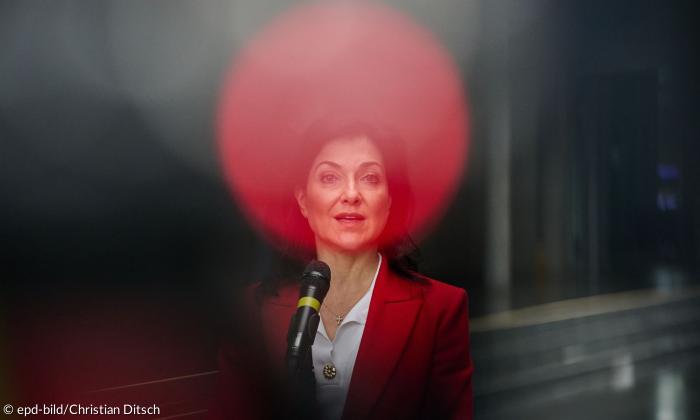 Eine Frau, durch eine Reflexion hat sie eine rote Blase um ihren Kopf, der aussieht wie ein Heiligenschein