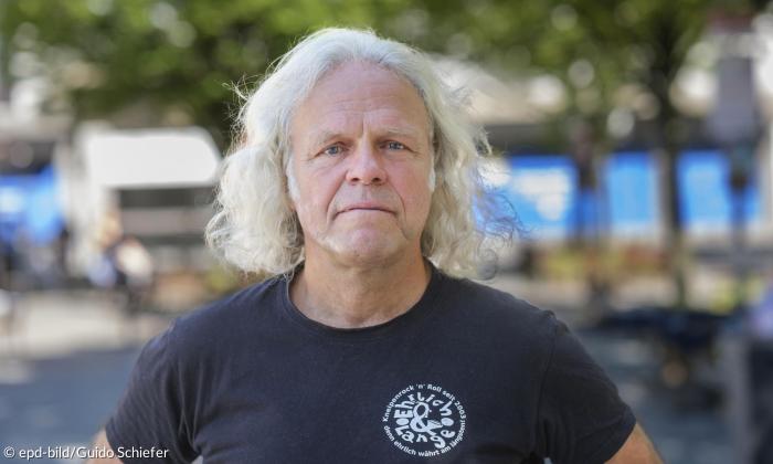 Ein Mann mit längeren weißen Haaren