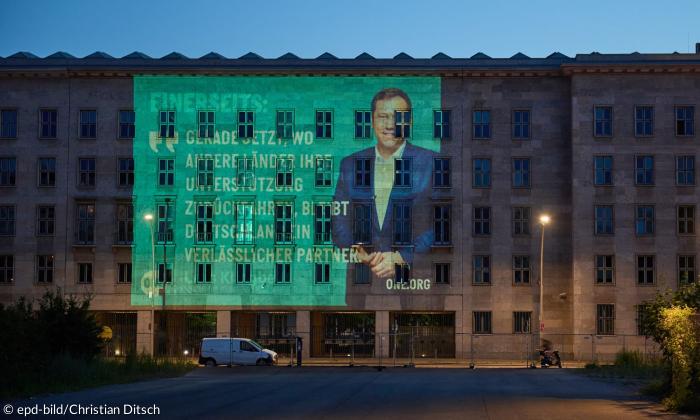 Ein Haus, an dessen Fassade ein großes Bild projiziert wird