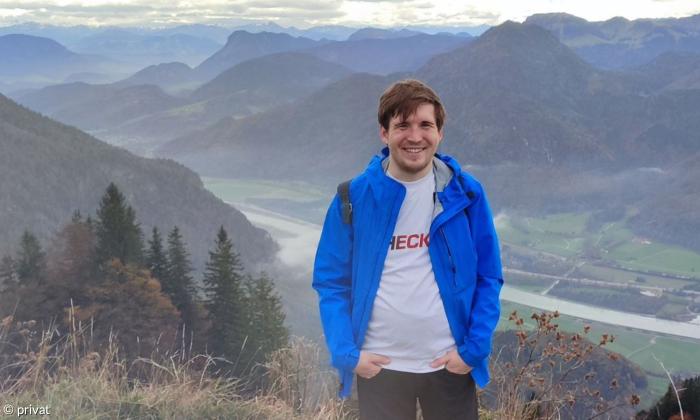 Ein junger Mann vor einer Bergkulisse