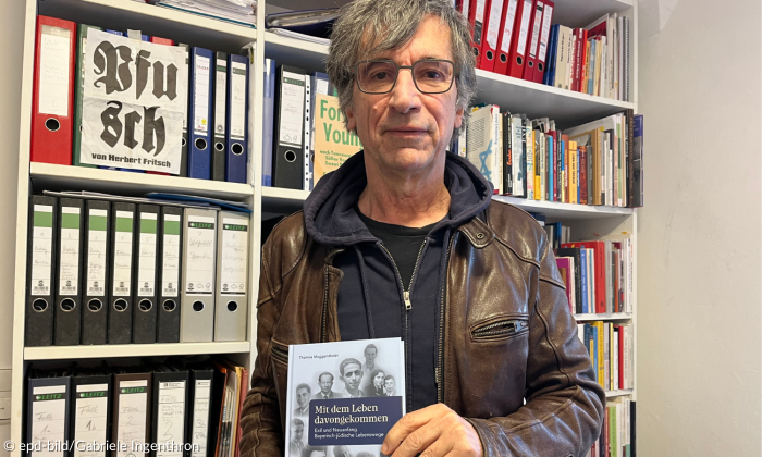 Thomas Muggenthaler vor einem Bücherregal