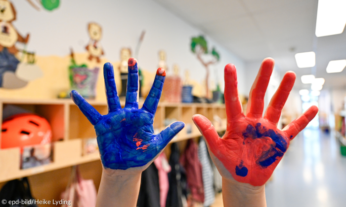 Bemalte Kinderhände rot und blau im Kindergarten