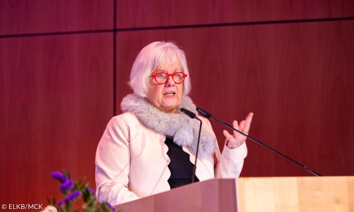 Eine Frau mit roter Brille am Rednerpult