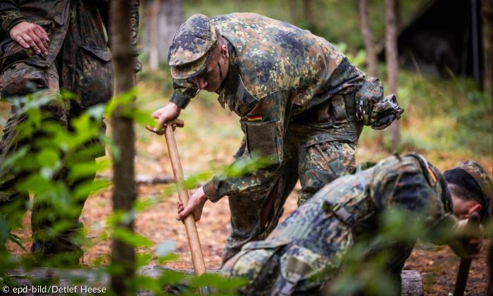 Männer in Uniformen kriechen im Wald herum