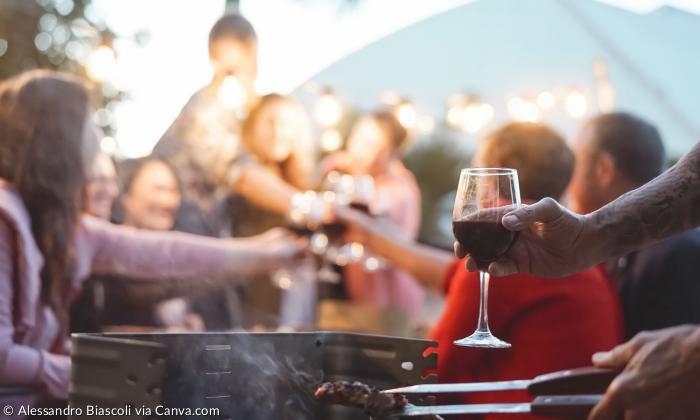 Menschen sitzen unter freiem Himmel, grillen, trinken