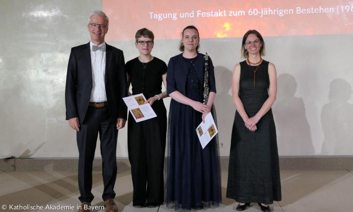Vier Menschen in schwarz gekleidet stehen nebeneinander