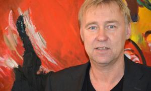 Der Regensburger Theater-Intendant Jens Neundorff von Enzberg vor einem Gemälde in seinem Büro.