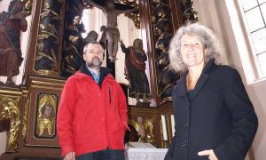 Pfarrerin Barbara Eberhard und Kirchen-Historiker Matthias Görtz vor dem Altar der Kirche in Frauenaurach.