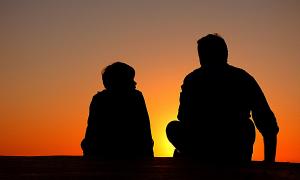 Vater und Sohn beobachten Sonnenuntergang