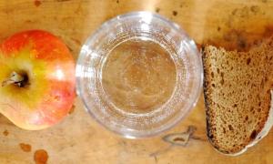 Apfel mit Glas Wasser und einer Scheibe Brot