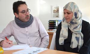 Integrationshelfer der Diakonie Würzburg Arash Zehforoush hilft einer Mutter.