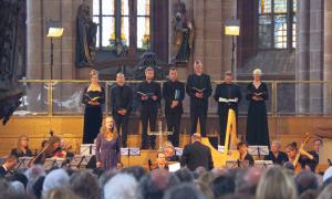Menschen stehen in einer Kirche mit Büchern in der Hand