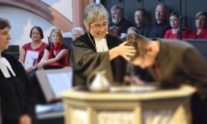 Regionalbischöfin Dorothea Greiner tauft iranische Geflüchtete.